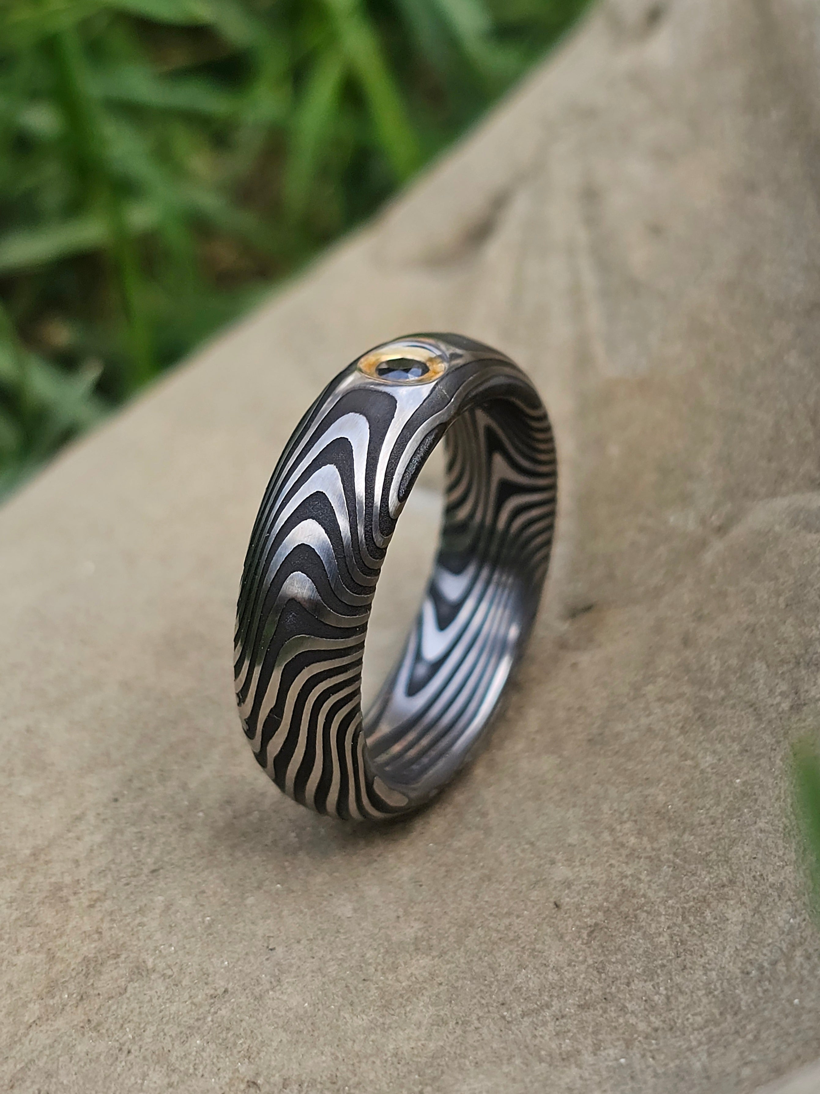 Anello in acciao damasco inox con diamante nero avvolto in fascia d'oro giallo 18kt