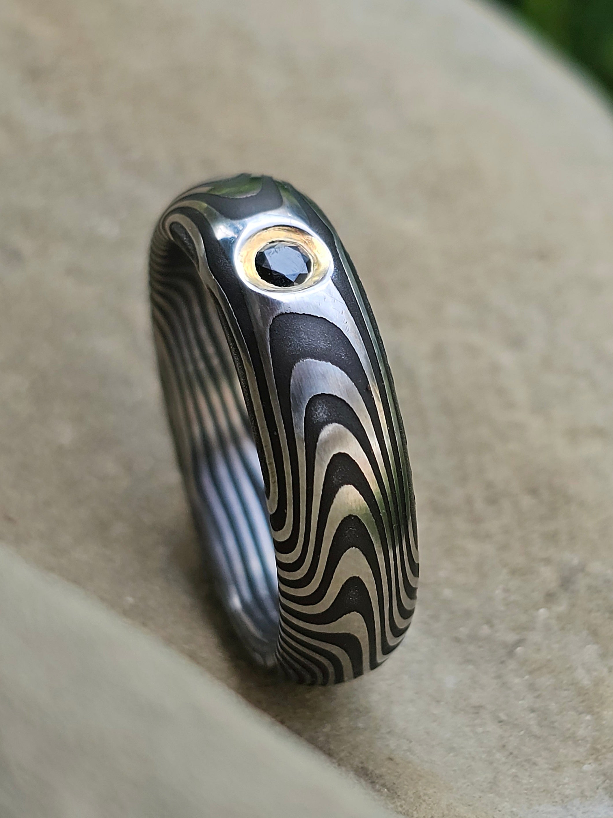 Anello in acciao damasco inox con diamante nero avvolto in fascia d'oro giallo 18kt